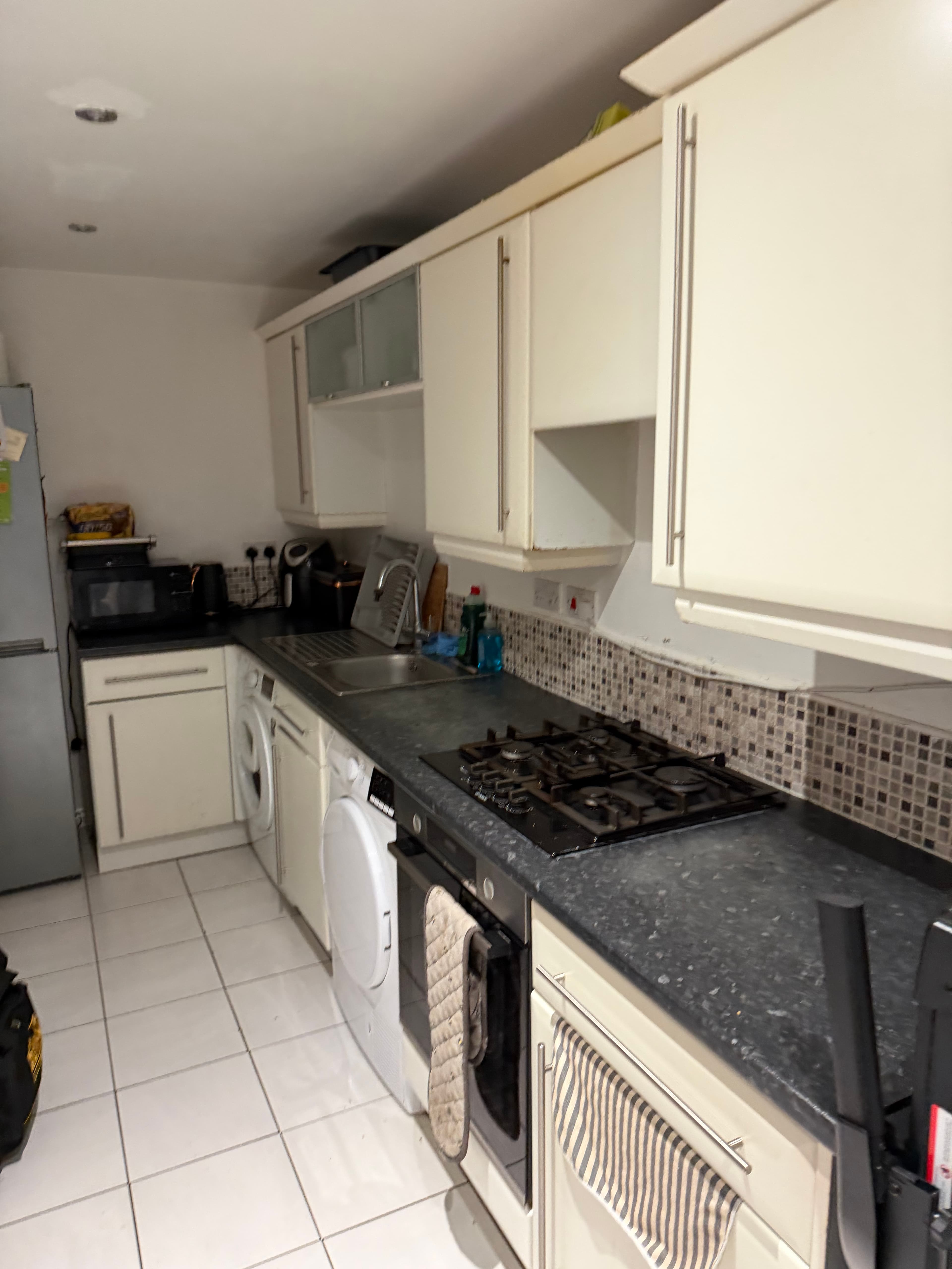 Cream kitchen before matt black vinyl wrap in Sheffield