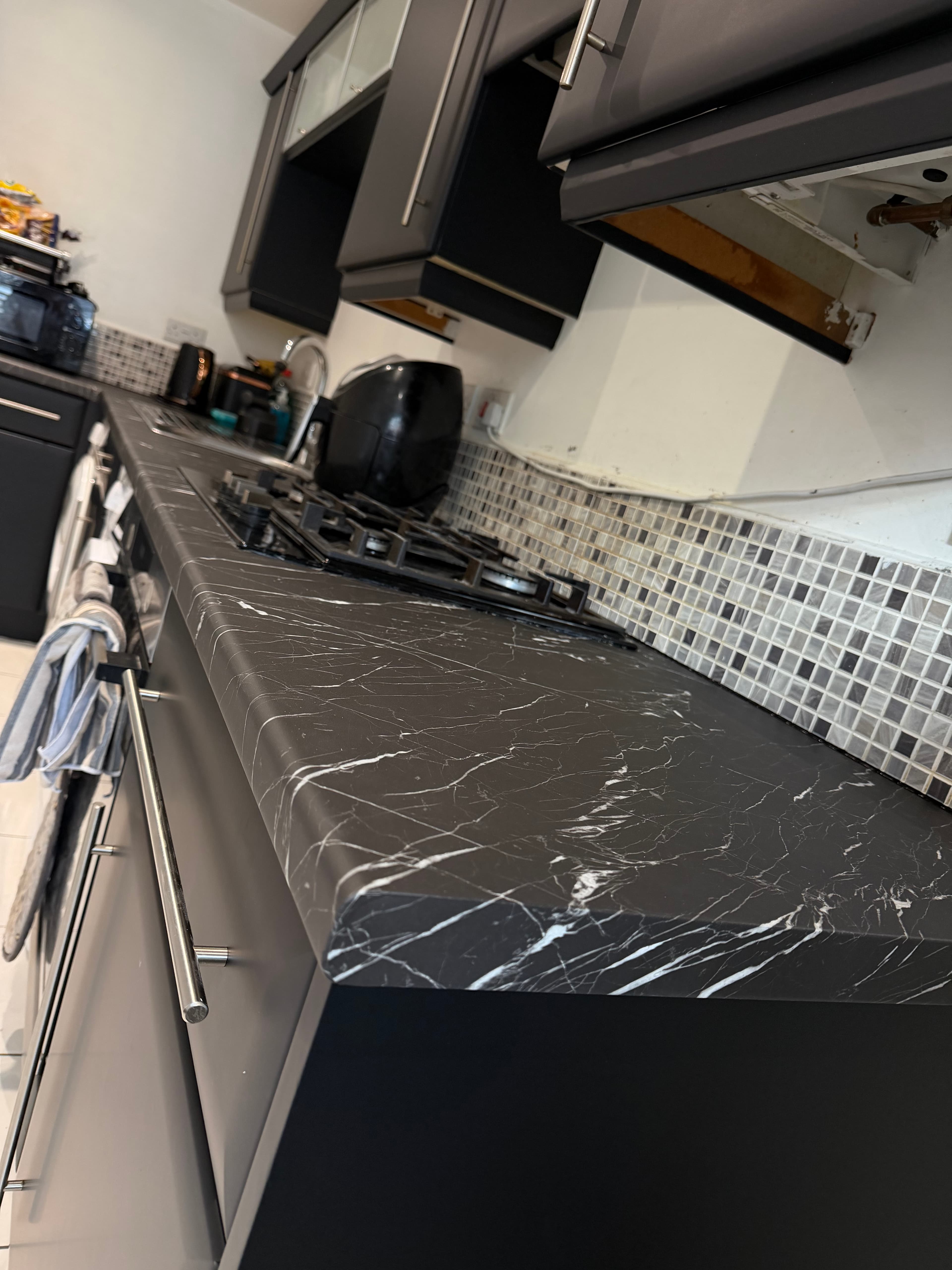 Black marble-effect worktop wrap and matt charcoal kitchen cabinets in Sheffield